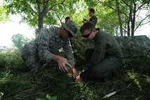 GARRISON, N.D. – Aircrew members from the 23rd Bomb Squadron and the 54th Helicopter Squadron, build shelter during combat skills training here, July 11. The refresher course helped sharpen aircrew member’s skills in order for them to be properly prepared for real world survival scenarios. (U.S. Air Force photo/Senior Airman Brittany Y. Auld)