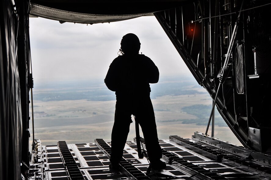 Master Sgt. Wayne Barna, a loadmaster attached to the 911th Airlift Wing, 758th Airlift Squadron, looks out the cargo door of a C-130 Hercules, moments after a heavy equipment platform weighing more than 3,000 pounds was dropped out of the aircraft above its designated drop zone in Cadiz, Ohio, July 14, 2012. The land, owned by Consol Energy, is one of two drop zones the 911th Airlift Wing regularly uses to practice its air drop procedures. The 911th AW’s main mission is to provide airlift of airborne forces, their equipment and supplies, but is also responsible for the delivery of these forces and materials by air drop, landing or cargo extraction systems. (U.S. Air Force photo by Senior Airman Jonathan Hehnly/Released)