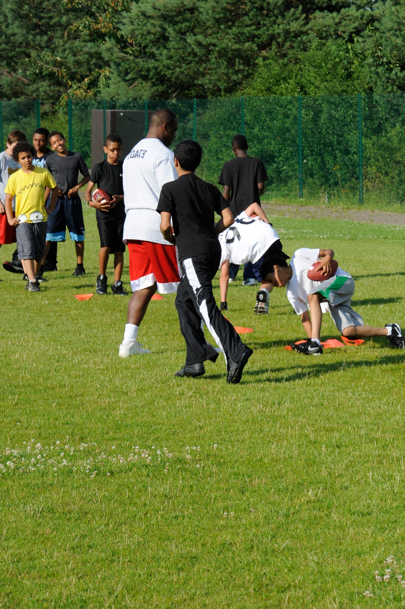 Athletes at the youth football camp practice different drills improving their abilities on Ramstein Air Base, Germany, July 10, 2012. The camp is geared toward teaching  participants teamwork and football techniques. (U.S. Air Force photo/ Senior Airman Aaron-Forrest Wainwright)

