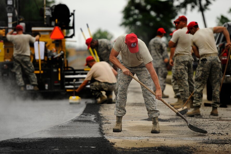 A U.S. Air Force Airman assigned to the 823rd RED HORSE Squadron, shovels loose asphalt from the road side while his team repaves Aiken Street, Shaw Air Force Base S.C., July 12, 2012. A team of 21 Airmen assigned to the 823rd RHS are slated to repave just over a mile of Shaw roadway. The 823rd RHS is an Air Combat Command asset assigned to the Ninth Air Force that operates out of Hurlburt Field, Fla. RED HORSE stands for Rapid Engineer Deployable Heavy Operational Repair Squadron Engineer. (U.S. Air Force photo by Senior Airman Kenny Holston/Released)  