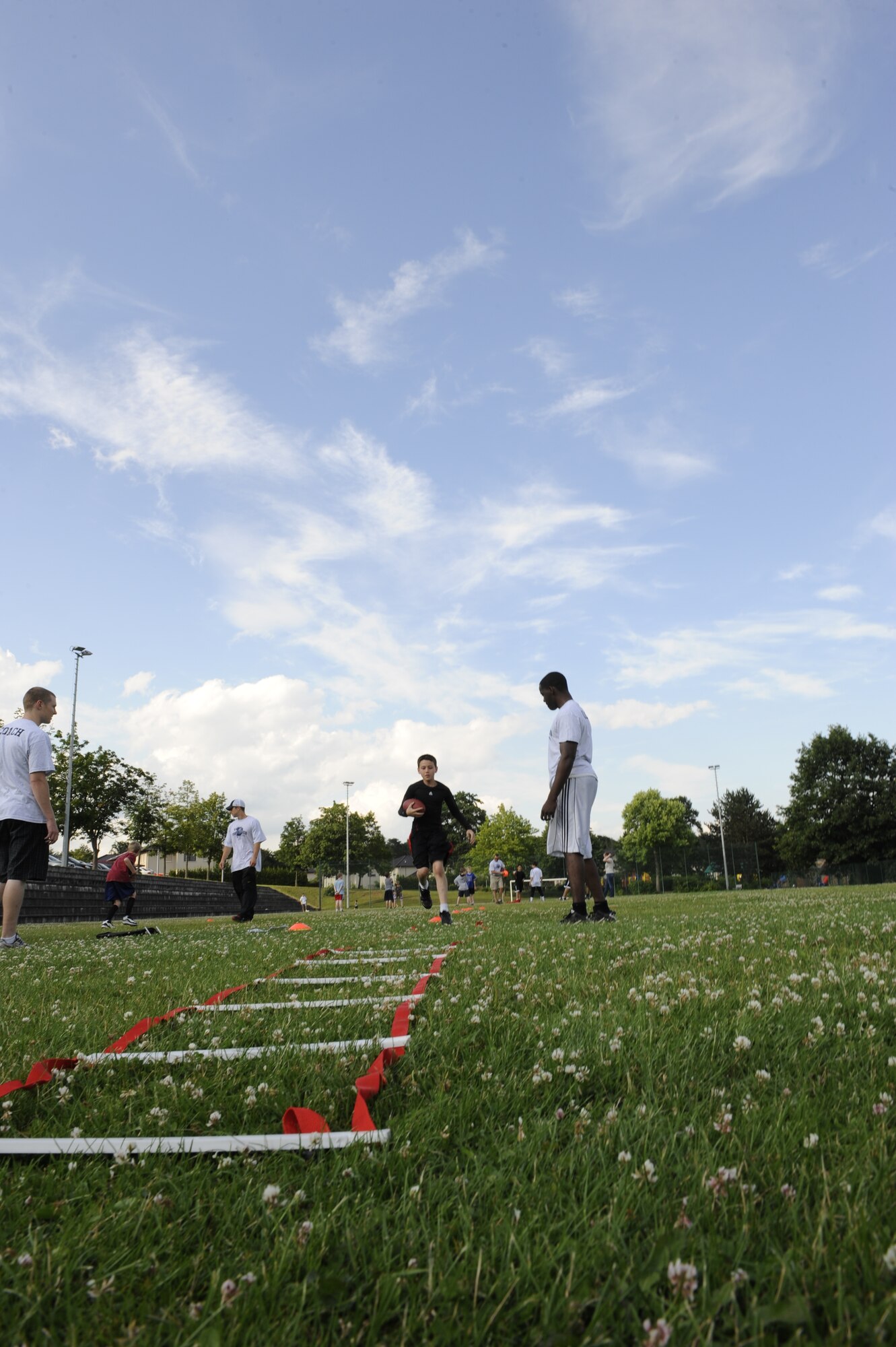 Athletes at the youth football camp practice different drills improving their abilities on Ramstein Air Base, Germany, July 10, 2012. The camp is geared toward teaching  participants teamwork and football techniques. (U.S. Air Force photo/ Senior Airman Aaron-Forrest Wainwright)

