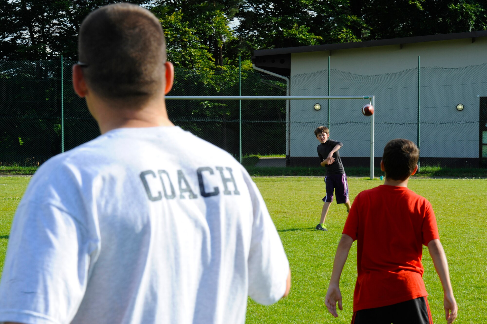 Athletes at the youth football camp practice different drills improving their abilities on Ramstein Air Base, Germany, July 10, 2012. The camp is geared toward teaching  participants teamwork and football techniques. (U.S. Air Force photo/ Senior Airman Aaron-Forrest Wainwright)
