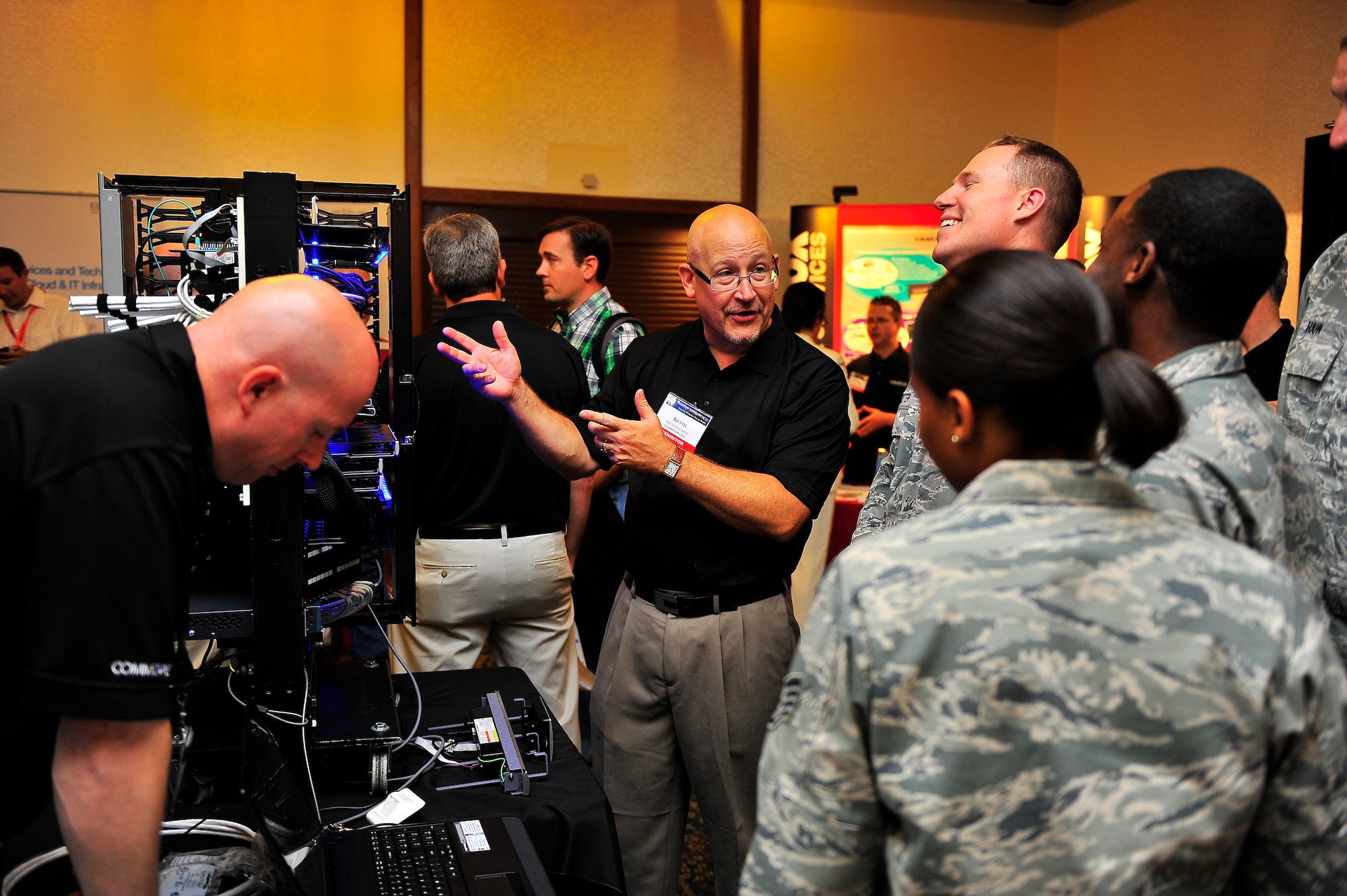 The Kaiserslautern Armed Forces Communications and Electronics Association, Chapter 158 hosted the 2012 Technology Expo at the Officer’s Club on Ramstein Air Base, Germany, July 17, 2012.  The event themed, "Discovering solutions for every mission" wowed more than 700 military members, civilians and contractors on the advances in modern technology to support global warfighting capabilities.  Attendees sign-in before entering the event..  CommScope representative explains the the make up of the featured system.  (U.S. Air Force photo/Staff Sgt. Daylena Gonzalez) 
