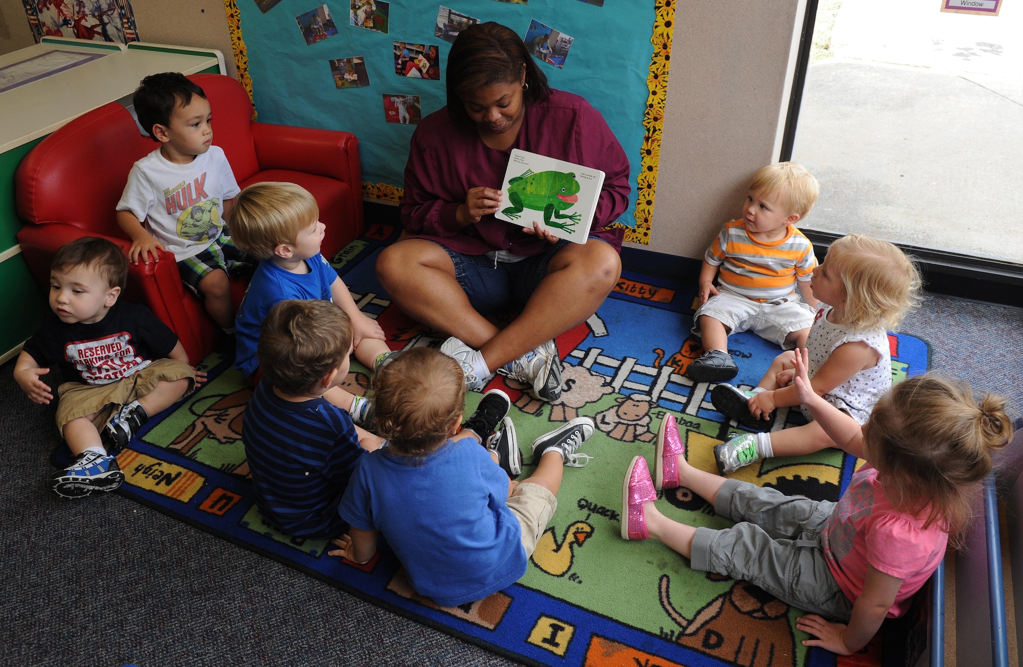 Cheryl Townsend, room lead teacher, reads a book to kids July 10, at Little Rock Air Force Base, Ark. The teachers in the one to two year olds teach kids how to sit quietly and participate during story time. (U.S. Air Force photo by Airman 1st Class Ellora Remington)