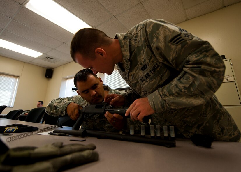 Senior Airman Nicholas Navarro, left, and Senior Airman Kristopher Hyatt, right, 7th Security Forces Squadron, reassemble a MCS 870 shotgun during the classroom portion of a qualification course, July 13, 2012, at Dyess Air Force Base, Texas. During the classroom segment, Airmen learned how to handle, reload, disassemble and reassemble their weapon. The MCS 870 shotgun is a 12-gauge, pump action, manually operated, tubular magazine, internal hammered, air-cooled, shoulder fired weapon used for close-quarter-combat. The shotgun is also capable of being loaded with lethal and non-lethal rounds making it ideal for breaching and riot control.  (U.S. Air Force photo by Airman 1st Class Damon Kasberg/Released)
