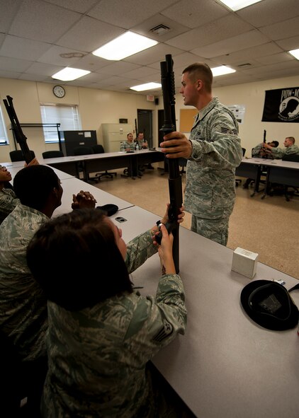 Senior Airman Matthew Smith, 7th Security Forces Squadron, teaches the classroom portion of a qualification course for the MCS 870 shotgun July 13, 2012, at Dyess Air Force Base, Texas. During the classroom segment, Airmen learned how to handle, reload, disassemble and reassemble their weapon. The MCS 870 shotgun is a 12-gauge, pump action, manually operated, tubular magazine, internal hammered, air-cooled, shoulder fired weapon used for close-quarter-combat. The shotgun is also capable of being loaded with lethal and non-lethal rounds making it ideal for breaching and riot control.  (U.S. Air Force photo by Airman 1st Class Damon Kasberg/Released)