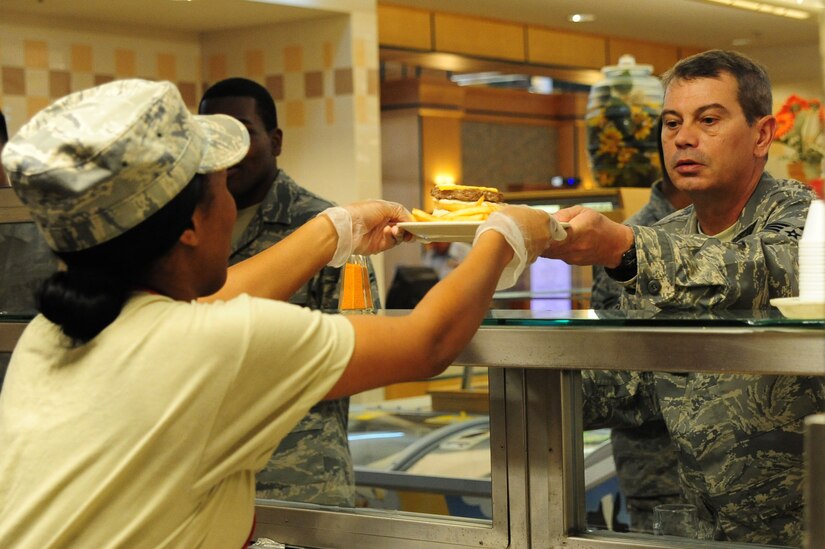 Airman 1st Class Ashli Green, 437th Force Support Squadron journeyman, hands an Airman a plate at the Joint Base Charleston – Air Base, S.C., Gaylor Dining Facility, July 9, 2012. The Gaylor Dining Facility supports the 437th and 315th Airlift Wings and the 628th Air Base Wing by providing more than 211,000 hot, nutritious meals annually. (U.S. Air Force photo/ Airman 1st Class Chacarra Walker) 