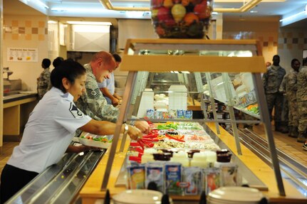 Airmen prepare their salads at the Joint Base Charleston – Air Base, S.C., Gaylor Dining Facility, July 9, 2012. The facility supports the 437th and 315th Airlift Wings and the 628th Air Base Wing by providing more than 211,000 hot, nutritious meals annually. The Gaylor Dining Facility offers cafeteria-style and self-serve breakfast, lunch, dinner and midnight meals. The modern facility has full-service snack and main-entrée lines, a full salad and pastry bar and an ice cream bar. (U.S. Air Force photo/ Airman 1st Class Chacarra Walker)