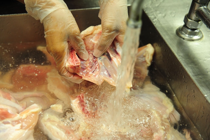 Airman 1st Class Ashli Green, 437th Force Support Squadron journeyman, cleans chicken at Joint Base Charleston – Air Base, S.C., Gaylor Dining Facility, July 9, 2012.  The Gaylor Dining Facility offers cafeteria-style and self-serve breakfast, lunch, dinner and midnight meals. The modern facility has full-service snack and main-entrée lines, a full salad and pastry bar and an ice cream bar. (U.S. Air Force photo/ Airman 1st Class Chacarra Walker)
