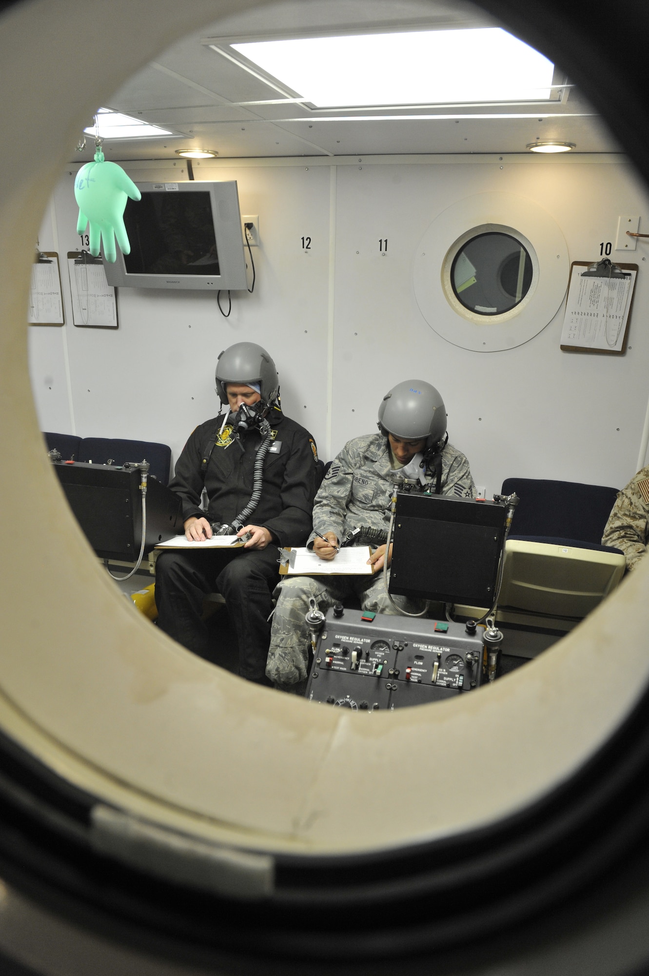 U.S. Air Force Staff Sgt. Josh Moreno, 24th Special Tactics Squadron parachutist, and U.S. Army Staff Sgt. Ryan Zimmerman, Golden Knights parachutist, fill out a worksheet during a hypoxia exercise in a chamber flight at Shaw Air Force Base, S.C., July 10, 2012. One of the main lessons instructors emphasize during each course is the danger of hypoxia. Hypoxia is a decrease of oxygen content in the blood that affects the brain and tissues of the body. (U.S. Air Force photo by Senior Airman Amber E. N. Jacobs/Released)