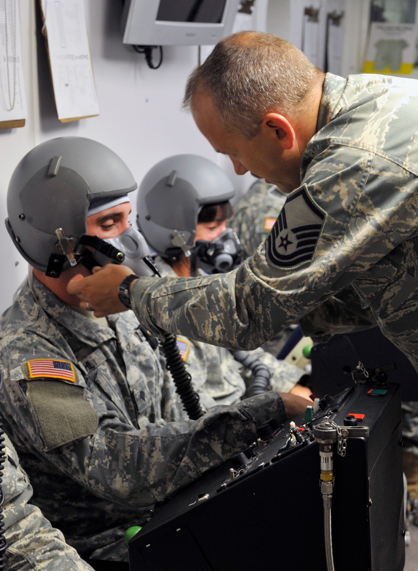 U.S. Air Force Master Sgt. Brian McKinney, 20th Aerospace Medicine Squadron aerospace and operational physiology technician, assists U.S. Army Spc. Christopher Stahl, a parachutist Ft. Bragg NC Airborne and Special Operations Test Directorate, with his oxygen mask at Shaw Air Force Base, S.C., July 10, 2012. The hypobaric chamber is used to simulate different altitudes pilots and crew members may experience during a mission and the different dangers that high altitudes may pose. (U.S. Air Force photo by Senior Airman Amber E. N. Jacobs/Released)