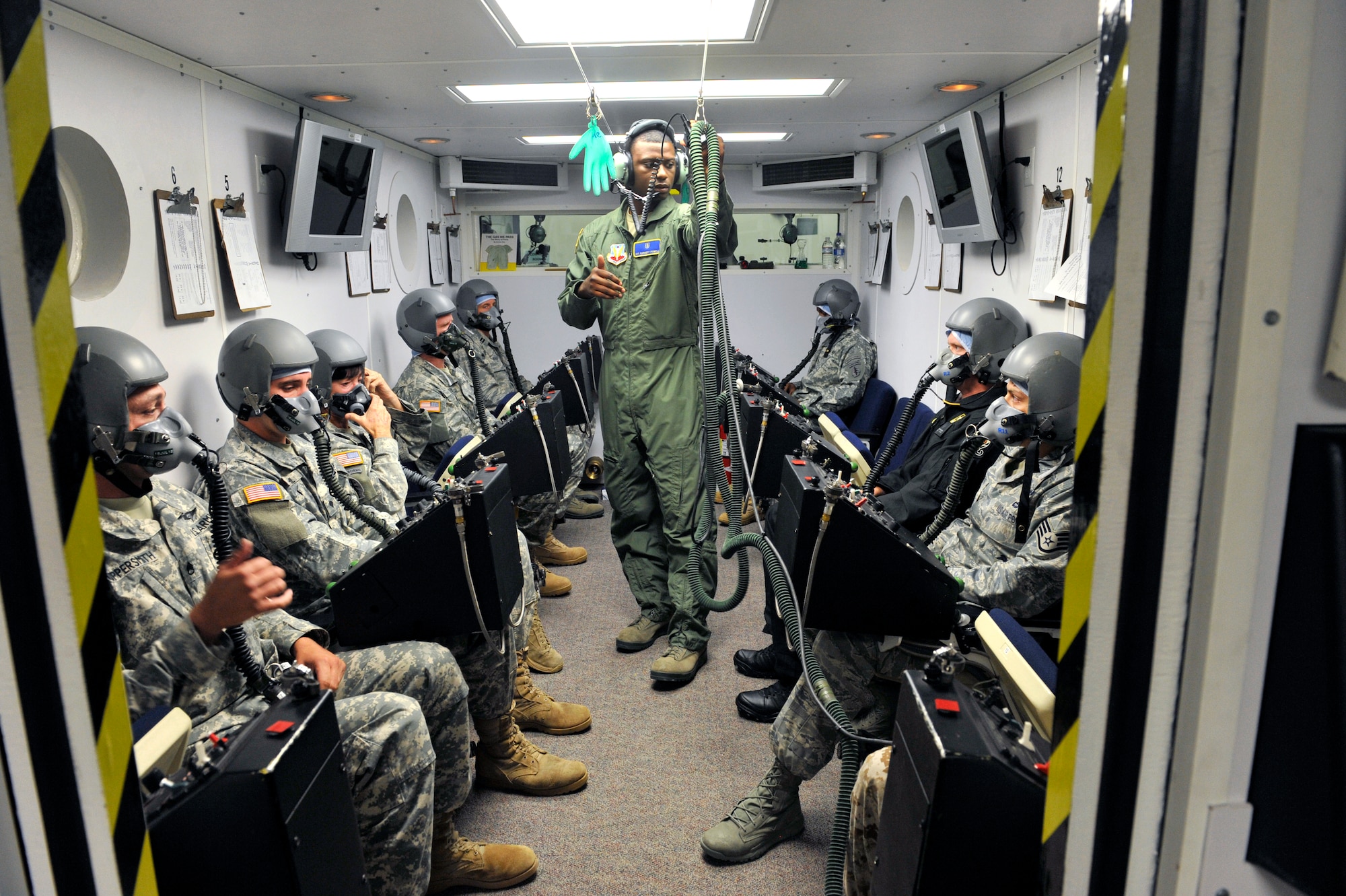 U.S. Air Force Airman 1st Class Earnest Powell, 20th Aerospace Medicine Squadron aerospace and operational physiology technician, briefs students on the equipment in an altitude chamber at Shaw Air Force Base, S.C., July 10, 2012. The hypobaric chamber is used to simulate different altitudes pilots and crew members may experience during a mission and the different dangers that high altitudes may pose. (U.S. Air Force photo by Senior Airman Amber E. N. Jacobs/Released)