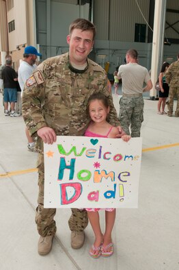 Tech. Sgt. Jeremy Fallecker, Flight Engineer with the 130th Airlift Wing, West Virginia Air National Guard, poses with his daughter after returning to Charleston, West Virginia from a 120-day deployment to Afghanistan and Kuwait in support of Operation Enduring Freedom.  U.S. Air Force Photo by TSgt Bryan G. Stevens [Photo Released]