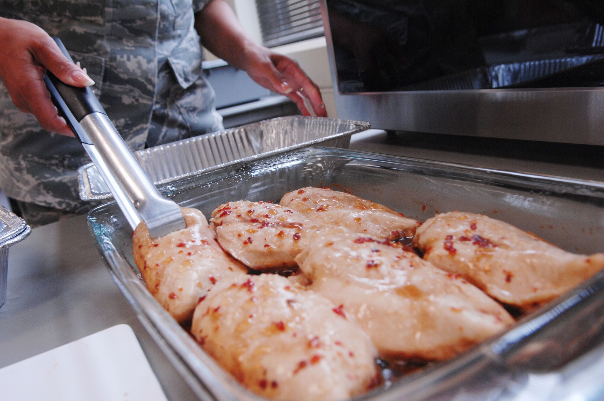 U.S. Air Force Tech. Sgt. Suzy Bright, 20th Aerospace Medicine Squadron health promotions NCOIC, prepares chicken at a microwave cooking class at the community center, Shaw Air Force Base, S.C., July 12, 2012.  The class provided Airmen with easy to cook recipes they can make in the dorms.(U.S. Air Force photo by Airman Nicole Sikorski/Released) 