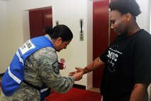U.S. Air Force Master Sgt. Leah Saenz, 35th Medical Group NCO in charge of education and training, puts moulage paint on a simulated victim before an active shooter exercise at Misawa Air Base, Japan, July 17, 2012. The exercise tested the base’s ability to respond to a crisis situation in the event that a real-world threat occurs. (U.S. Air Force photo by Airman 1st Class Kia Atkins/Released)