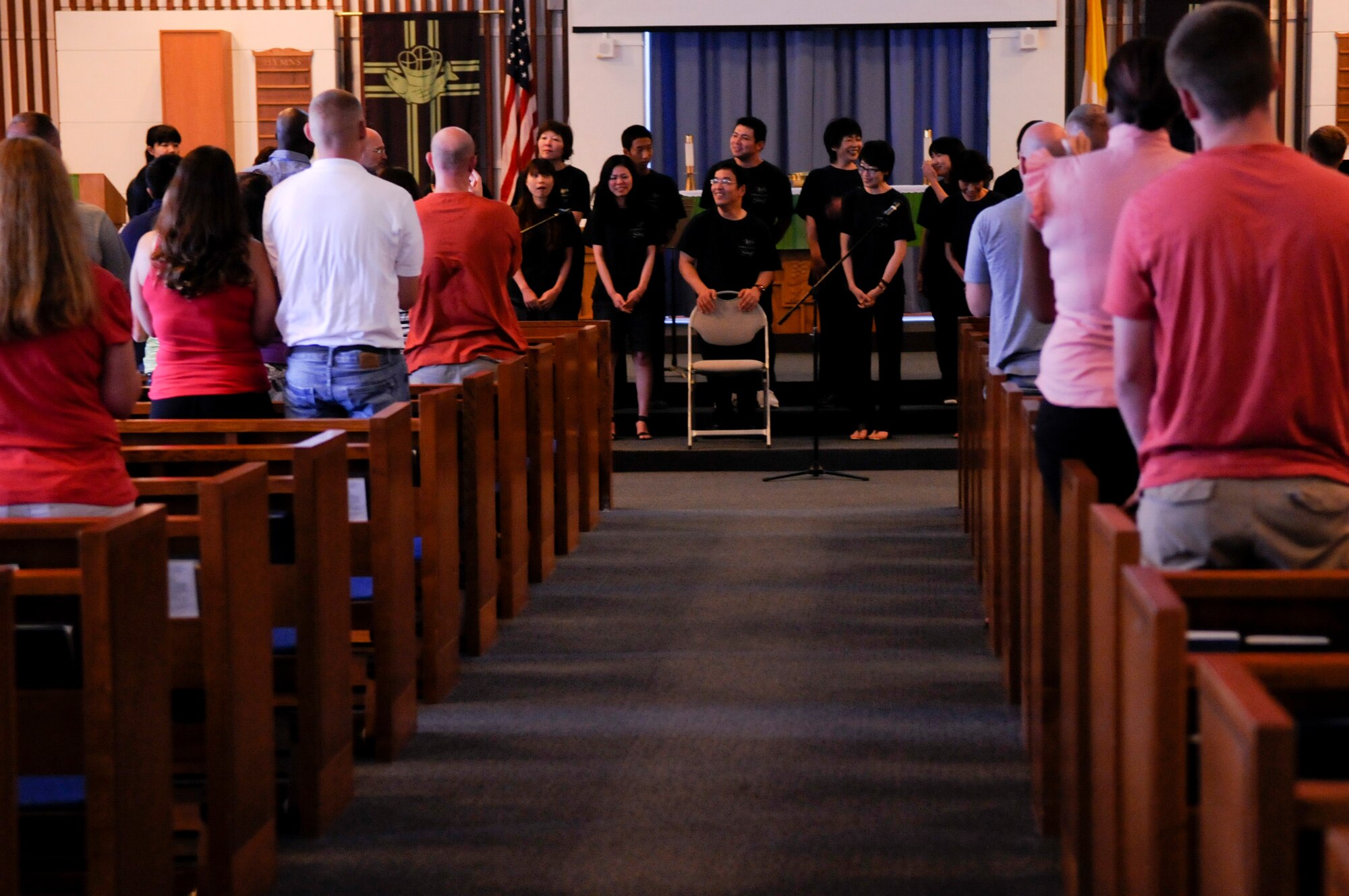 The Joyful Sounds Gospel Choir receives a standing ovation from the congregation during a service at Chapel 1 on Kadena Air Base, Japan, July 15, 2012. The choir left Miyazaki Prefecture in mainland Japan for the first time to travel to Okinawa and perform four shows on island. (U.S. Air Force photo/ Airman Tara A. Williamson)