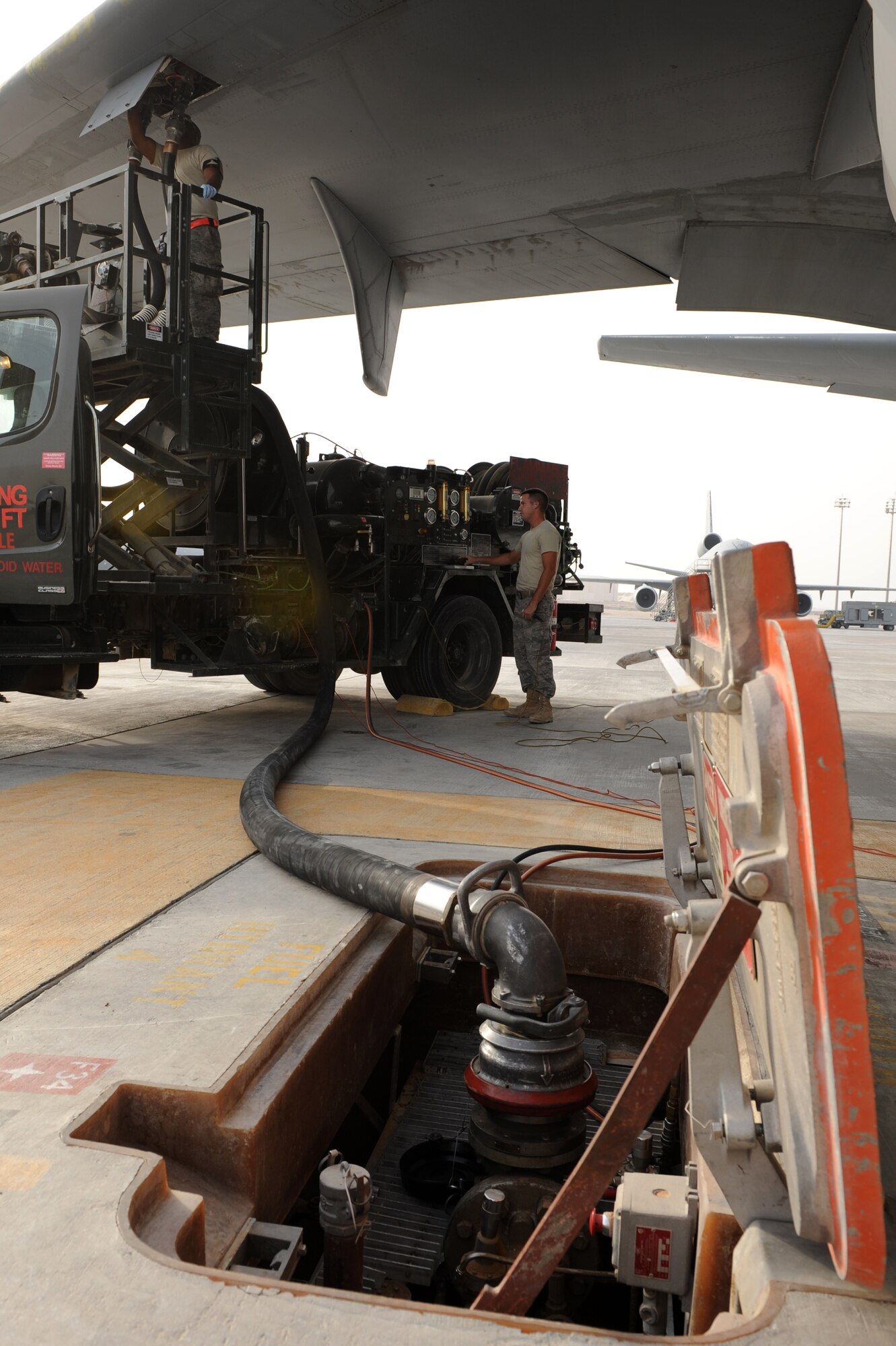 SOUTHWEST ASIA - U.S. Air Force Staff Sgt. Alvin Johnson, fuels distribution operator (top) and Staff Sgt. Jason Drobish, fuels distribution supervisor from the 380th Expeditionary Logistics Readiness Squadron Petroleum, Oils and Lubricants flight, provide fuel for a KC-10 Extender July 16, 2012. On average, the POL flight delivers 500,000 gallons of fuel to 380th Air Expeditionary Wing aircraft daily. (U.S. Air Force photo/Master Sgt. Scott MacKay)