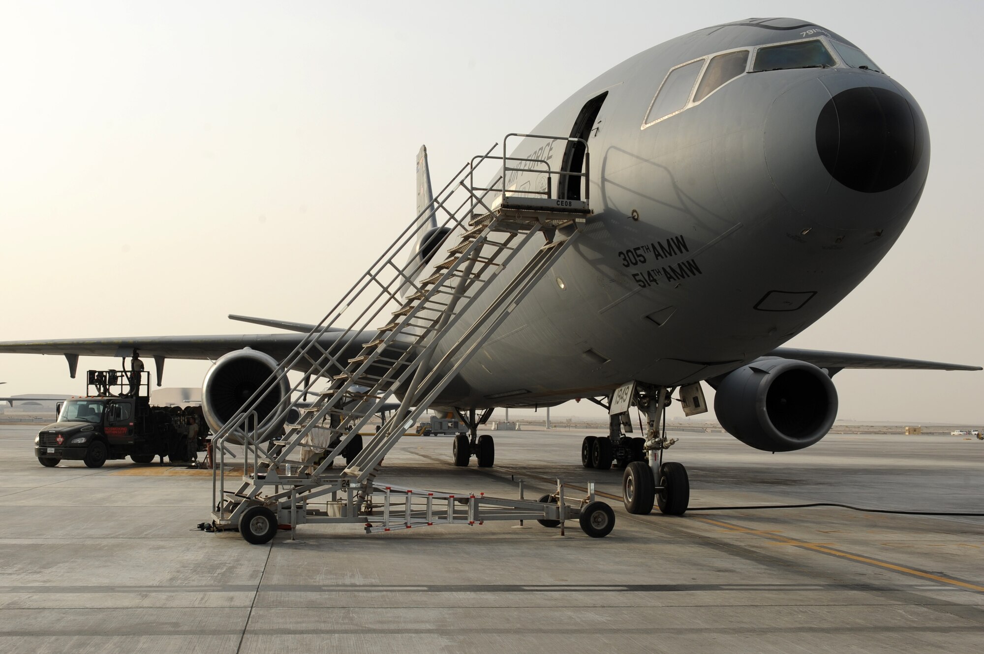 SOUTHWEST ASIA - Members of the 380th Expeditionary Logistics Readiness Squadron Petroleum, Oils and Lubricants flight provide fuel for a KC-10 Extender July 16, 2012. On average, the POL flight delivers 500,000 gallons of fuel to 380th Air Expeditionary Wing aircraft daily. (U.S. Air Force photo/Master Sgt. Scott MacKay)