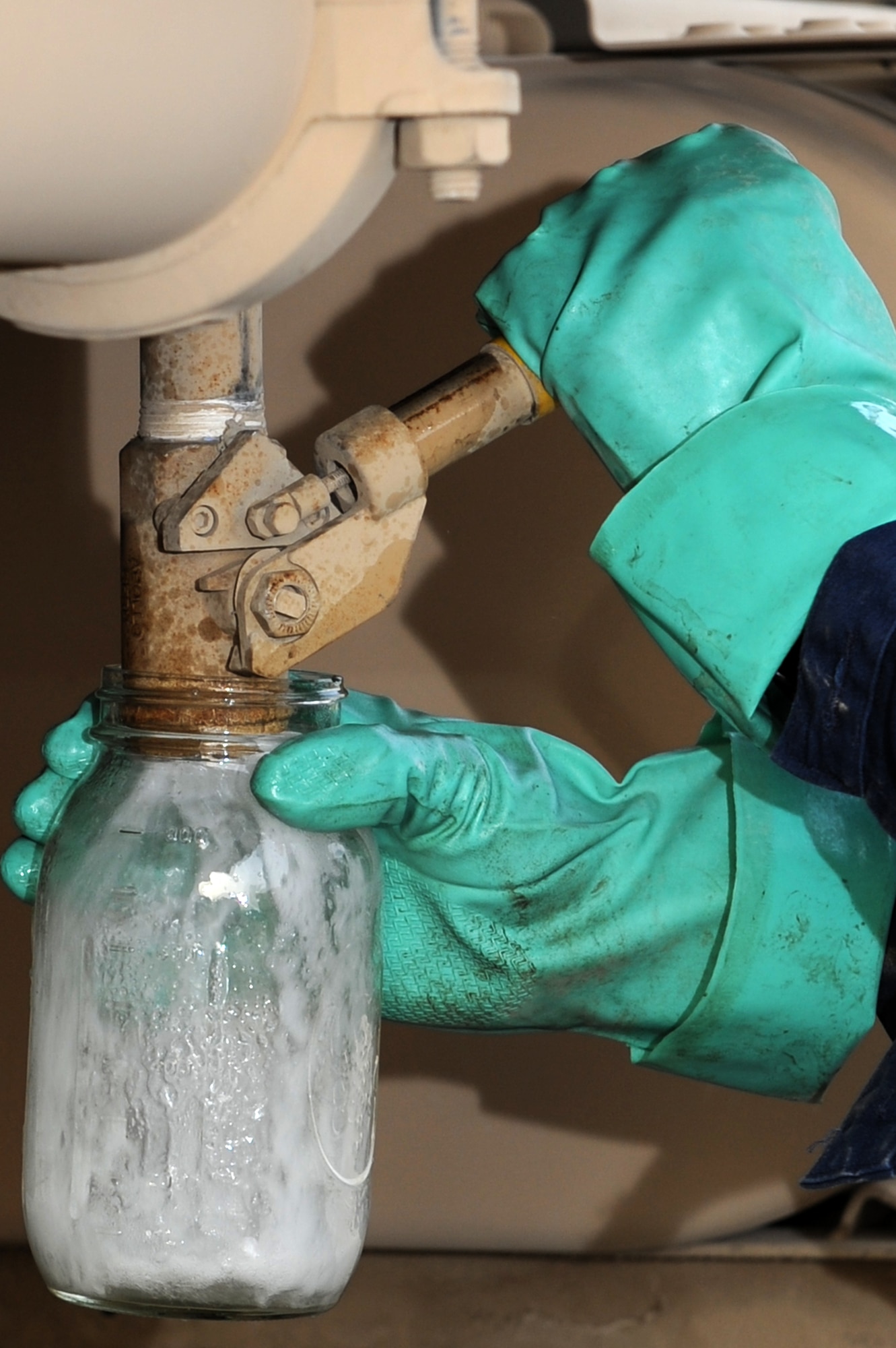 SOUTHWEST ASIA - U.S. Air Force Tech. Sgt. Charles Conley, 380th Expeditionary Logistics Readiness Squadron Petroleum, Oils and Lubricants flight NCO in charge of preventative maintenance, takes a fuel sample from the sump of a fuel truck July 16, 2012. Conley, a Belleville, Ill. native, is deployed from Scott Air Force Base, Ill. (U.S. Air Force photo/Master Sgt. Scott MacKay)
