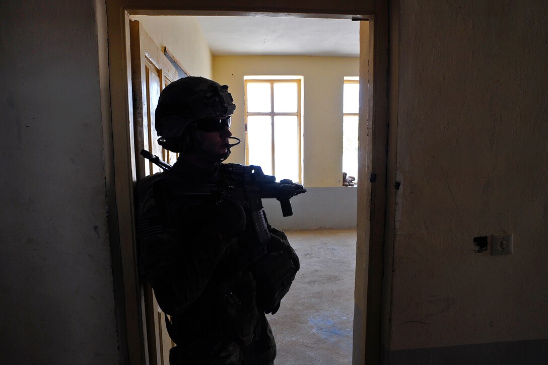 U.S. Army Sgt. 1st Class Michael Nelson provides security from inside a building during a key leader engagement in Cin Farsi village, Farah province, Afghanistan, July 14, 2012. 