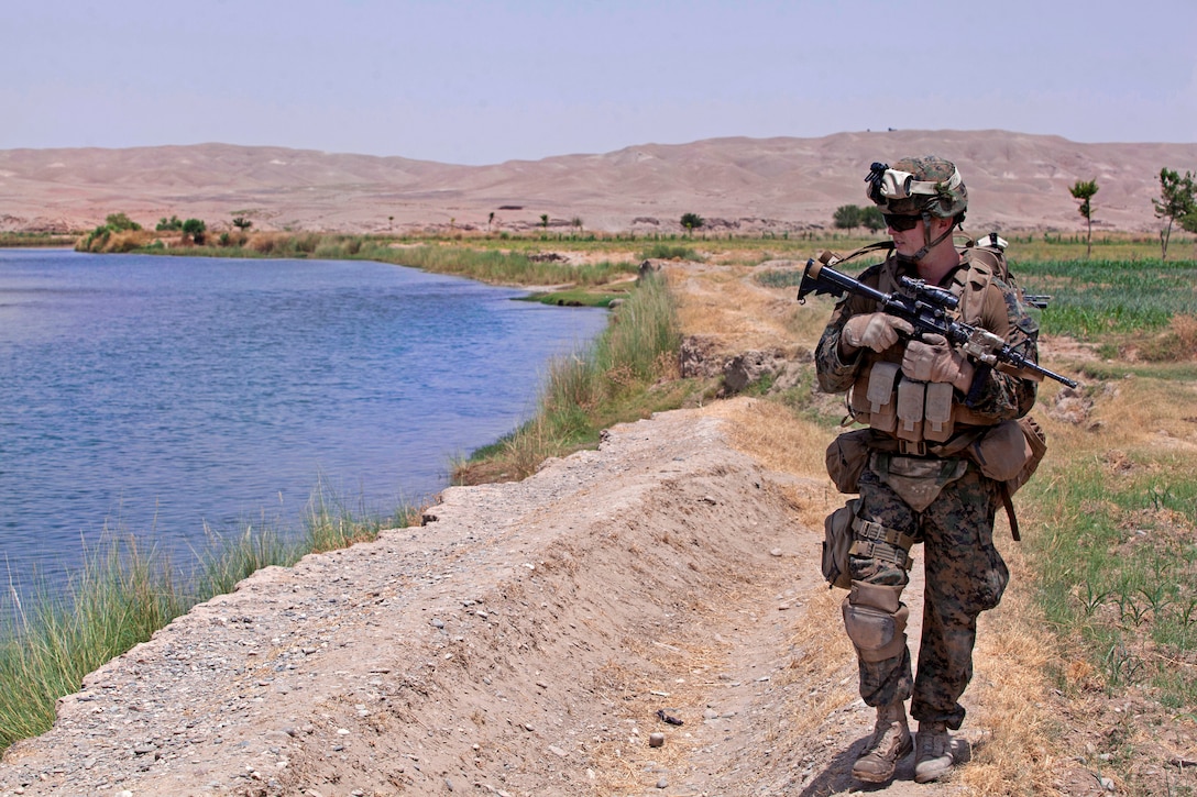 U.S. Navy Seaman Derek Happel patrols along the Helmand River in Sangin in Afghanistan's Helmand province, July 11, 2012. Happel, a hospitalman, is assigned to Alpha Company, 1st Battalion, 7th Marine Regiment, Regimental Combat Team 6.