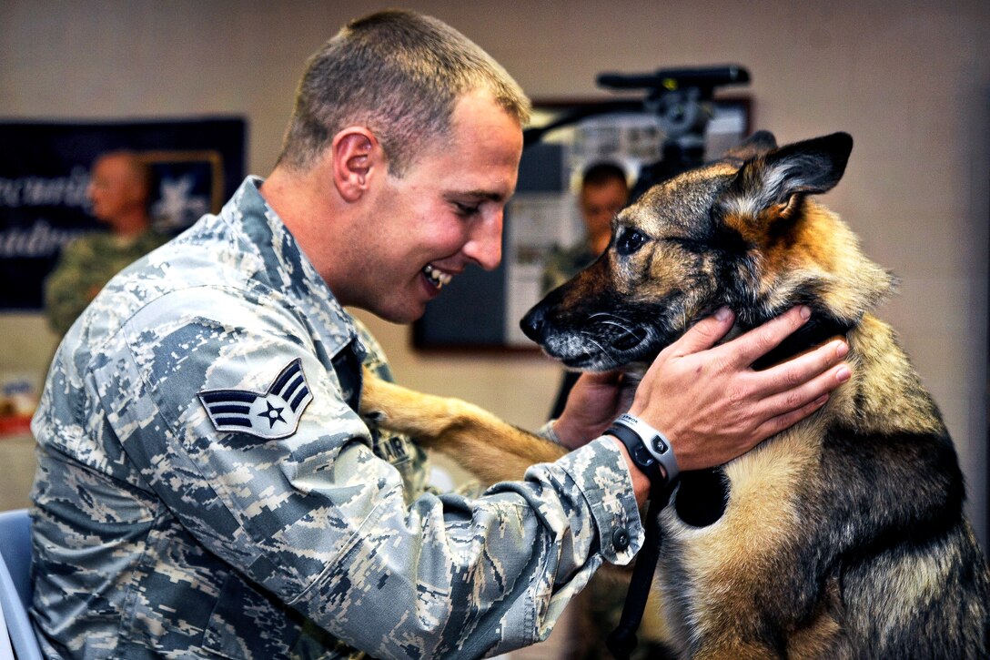 Air Force Senior Airman Brandon Denton plays with his partner, Conny, a military working dog, before her retirement ceremony on MacDill Air Force Base, Fla., July 12, 2012. Denton, a military working dog handler assigned to the 6th Security Forces Squadron, and Conny have been partners for two years. Denton adopted Conny upon her retirement.