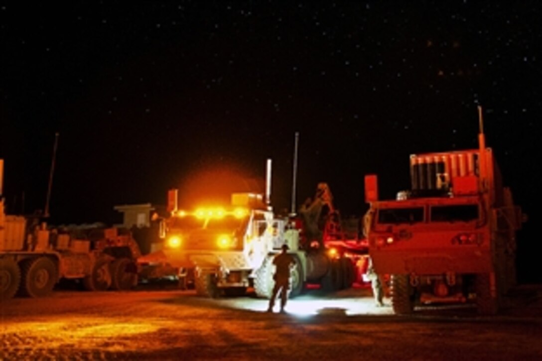 A U.S. paratrooper directs vehicles to be used for a combat logistics patrol mission on Forward Operating Base Arian in Afghanistan's Ghazni province, July 8, 2012.