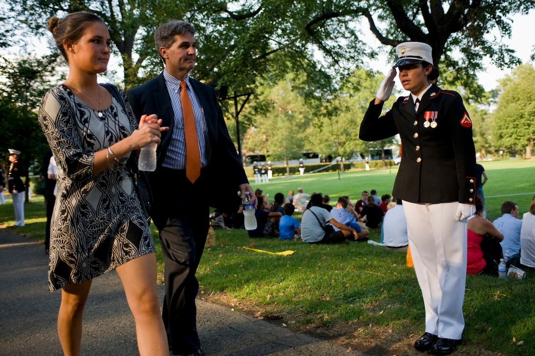Lance Cpl. Alexandria Smith, ceremonial hoster, salutes guests of the Tuesday Sunset Parade at the Marine Corps War Memorial, Arlington, Va., July 17.