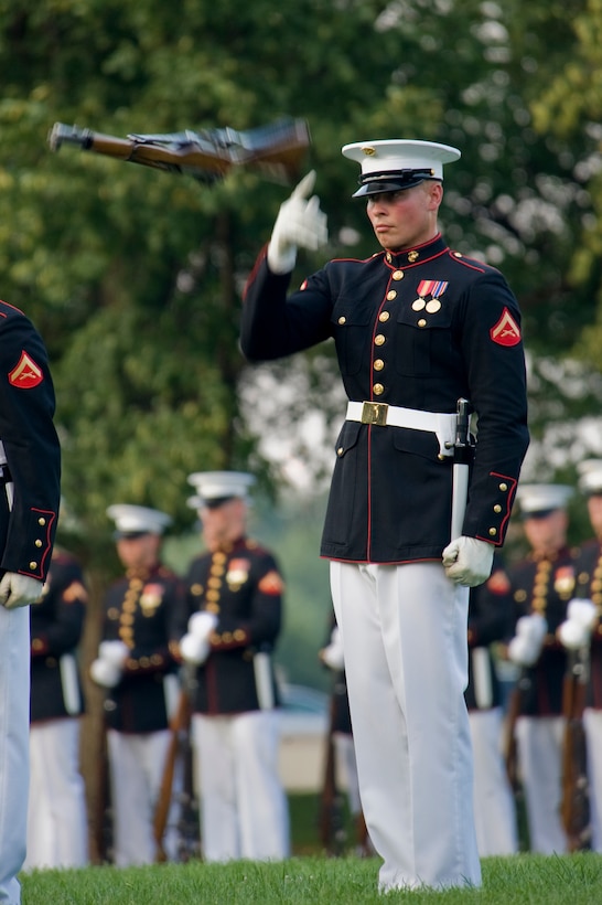 Lance Cpl. Shane Luikert, a Marine Corps Silent Drill Platoon single, executes a rifle toss during a Tuesday Sunset Parade at the Marine Corps War Memorial, Arlington, Va., July 17.