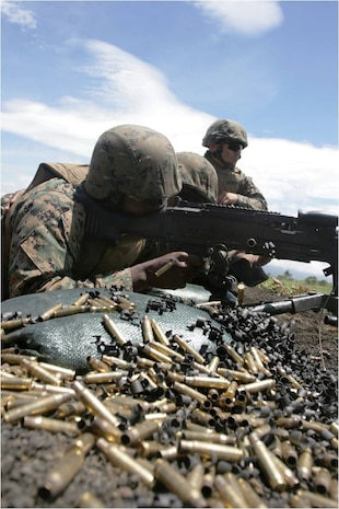 Staff Sgt. Leon F. Ellis, Jr., Combat Logistics Company 36 fire team gunner, fires an M240G while Lance Cpl. Jacklyn E. Erhunmwunsee, CLC-36 fire team leader, and Sgt. Delshan R. Martinez, CLC-36 post security officer, watch down range during automatic weapons training as part of Exercise Dragon Fire II at Combined Arms Combat Training Center Camp Fuji, Japan, July 16, 2012. Dragon Fire is an annual exercise that trains Marines and sailors in increasing their proficiency and efficiency with an assortment of weaponry.