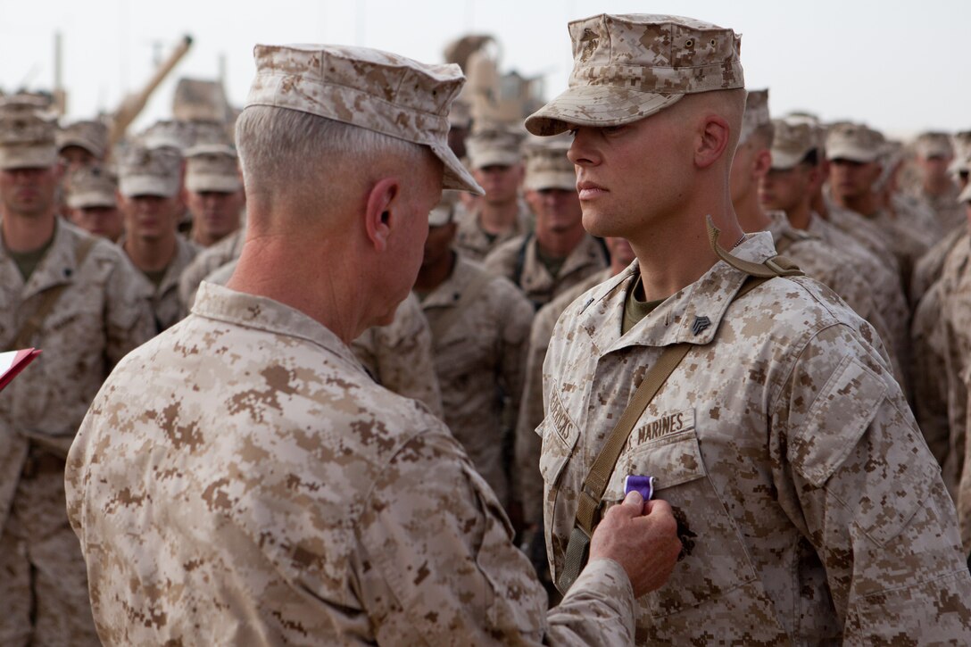 The Commandant of the Marine Corps Gen. James F. Amos pins a Purple Heart on Sgt. Shane Fredericks during a visit to Combat Outpost Shir Ghazi, Afghanistan, July 17, 2012. Fredericks, from Syracuse, N.Y., and an infantryman with 2nd Battalion, 5th Marine Regiment, suffered a concussion when the vehicle he was riding in struck an improvised explosive device explosion in Now Zad District, May 12, 2012. General Amos and Sgt. Maj. of the Marine Corps Micheal P. Barrett visited Marines throughout Helmand province, stopping at six bases. They thanked the Marines for their service and sacrifice and praised them for working hard to transition security in the region to Afghan forces.