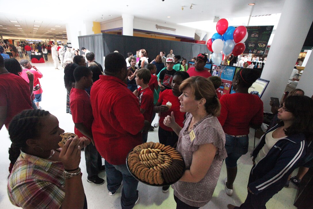 Marine and Family Programs division hands out cookies and cupcakes after a flash mob performance in the Marine Corps Exchange aboard Marine Corps Base Camp Lejeune July 13. Children Youth and Teen Program, family readiness officers, the MCCS Marketing Office and Exceptional Family Member Program staff participated.