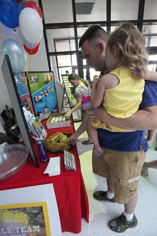 A Marine grabs a cookie for his daughter after a flash mob performance in the Marine Corps Exchange aboard Marine Corps Base Camp Lejeune July 13. Children Youth and Teen Program, family readiness officers, the MCCS Marketing Office and Exceptional Family Member Program staff participated.