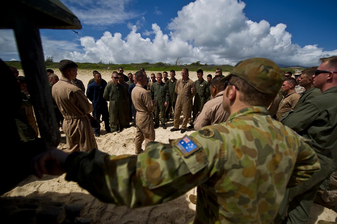 Marines assigned to Combat Assault Company, 3rd Marine Regiment, and Royal Australian Army Capt. Ken Semmens, cavalry officer from Townsville, Queensland, gather near the back of a R7-A1 amphibious assault vehicle on Pyramid beach for a safety briefing prior to splashing into the ocean July 12, to meet up with the USS Essex (LHD-2) off shore during the Rim of the Pacific Exercise 2012. Twenty-two nations, more than 40 ships and submarines, more than 200 aircraft and 25,000 personnel are participating in RIMPAC exercise from Jun. 29 to Aug. 3, in and around the Hawaiian Islands. The world's largest international maritime exercise, RIMPAC provides a unique training opportunity that helps participants foster and sustain the cooperative relationships that are critical to ensuring the safety of sea lanes and security on the world's oceans. RIMPAC 2012 is the 23rd exercise in the series that began in 1971.