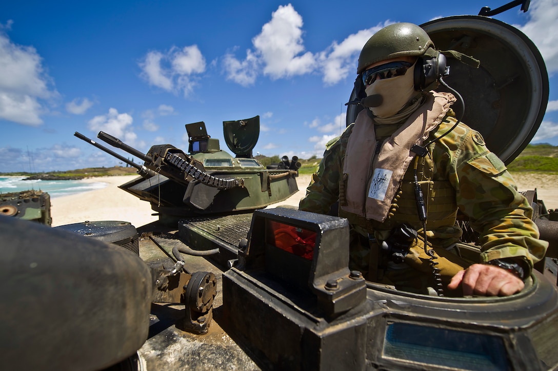 Royal Australian Army Capt. Ken Semmens, cavalry officer from Townsville, Queensland, Australia, waits atop a R7-A1 amphibious assault vehicle July 12, before departing out to sea for a joint mission with U.S. Marines from Combat Assault Company, 3rd Marine Regiment. Approximately 2,200 troops from nine countries are part of the Combined Force Land Component Command, and will be conducting amphibious and land-based operations throughout the exercise in order to enhance mutual capabilities and joint interoperability.