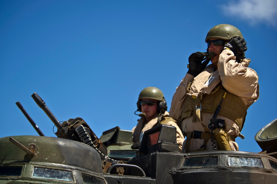 Sgt. Nolan Lynch, Combat Assault Company, 3rd Marine Regiment, communicates through a headset to the other Amphibious Assault Vehicle crew members prior to entering the water off Pyramid Rock beach July 12, to meet up with the USS Essex (LHD-2) off shore during Rim of the Pacific Exercise (RIMPAC) 2012. Approximately 2,200 troops from nine countries are part of the Combined Force Land Component Command, and will be conducting amphibious and land-based operations throughout the exercise in order to enhance mutual capabilities and joint interoperability.