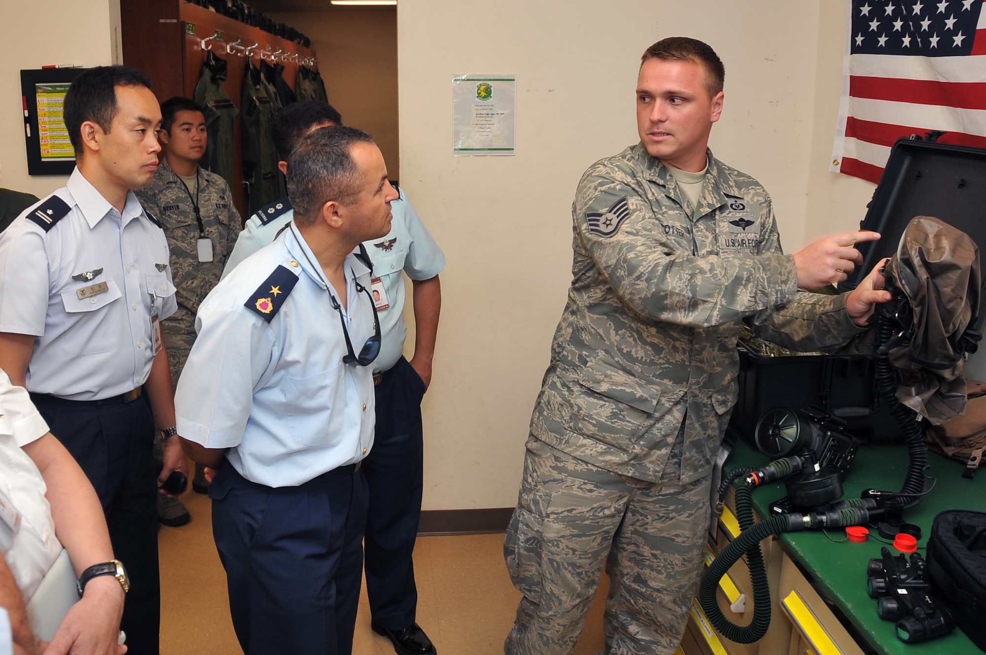 Staff Sgt. Louis Cotter (right), 51st Operations Support Squadron aircrew flight equipment craftsman, explains the use of the chemical mask to international pilots during their visit to the 25th Fighter Squadron July 17, 2012. More than 200 military members from 13 different countries traveled to Korea for a joint education endeavor at the Korea Joint Military University. The year-long course, similar to the Air Force’s Air Command and Staff College at Maxwell Air Force Base, Ala., teaches war theory, air and space power doctrine, joint Korea operations and planning processes. (U.S. Air Force photo/Staff Sgt. Craig Cisek)