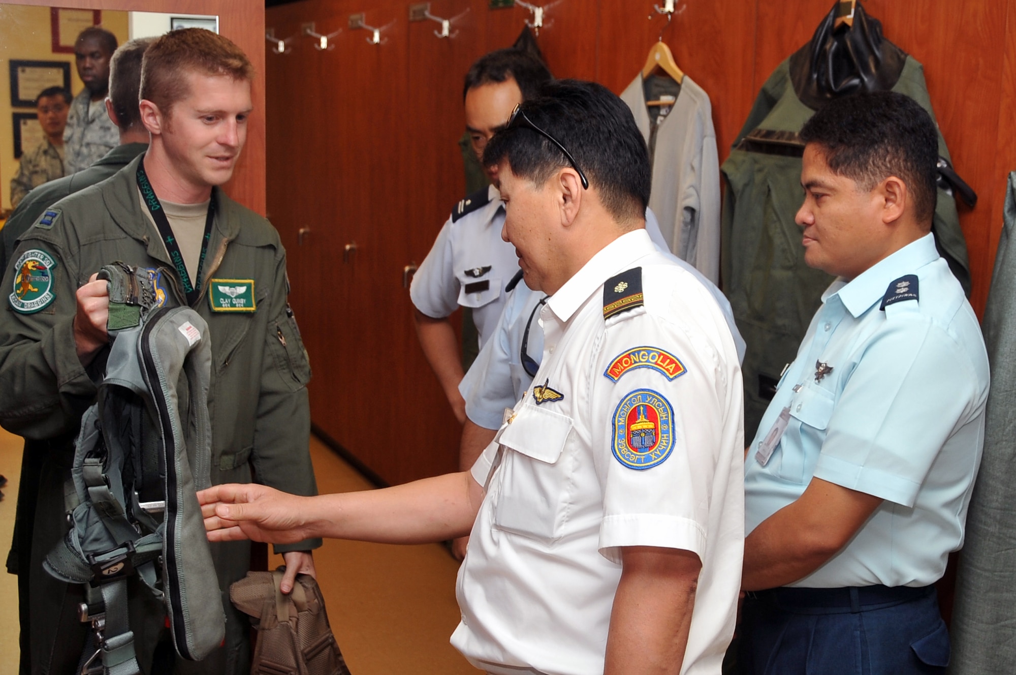 Capt. Clay Quinby (left), shows allied nation pilots the flight equipment used by U.S. Air Force pilots at Osan Air Base, Republic of Korea, July 17, 2012. The international pilots toured the 25th Fighter Squadron to learn about A-10 Thunderbolt II capabilities. Quinby is an A-10 Thunderbolt II pilot with the 25th Fighter Squadron. (U.S. Air Force photo/Staff Sgt. Craig Cisek)