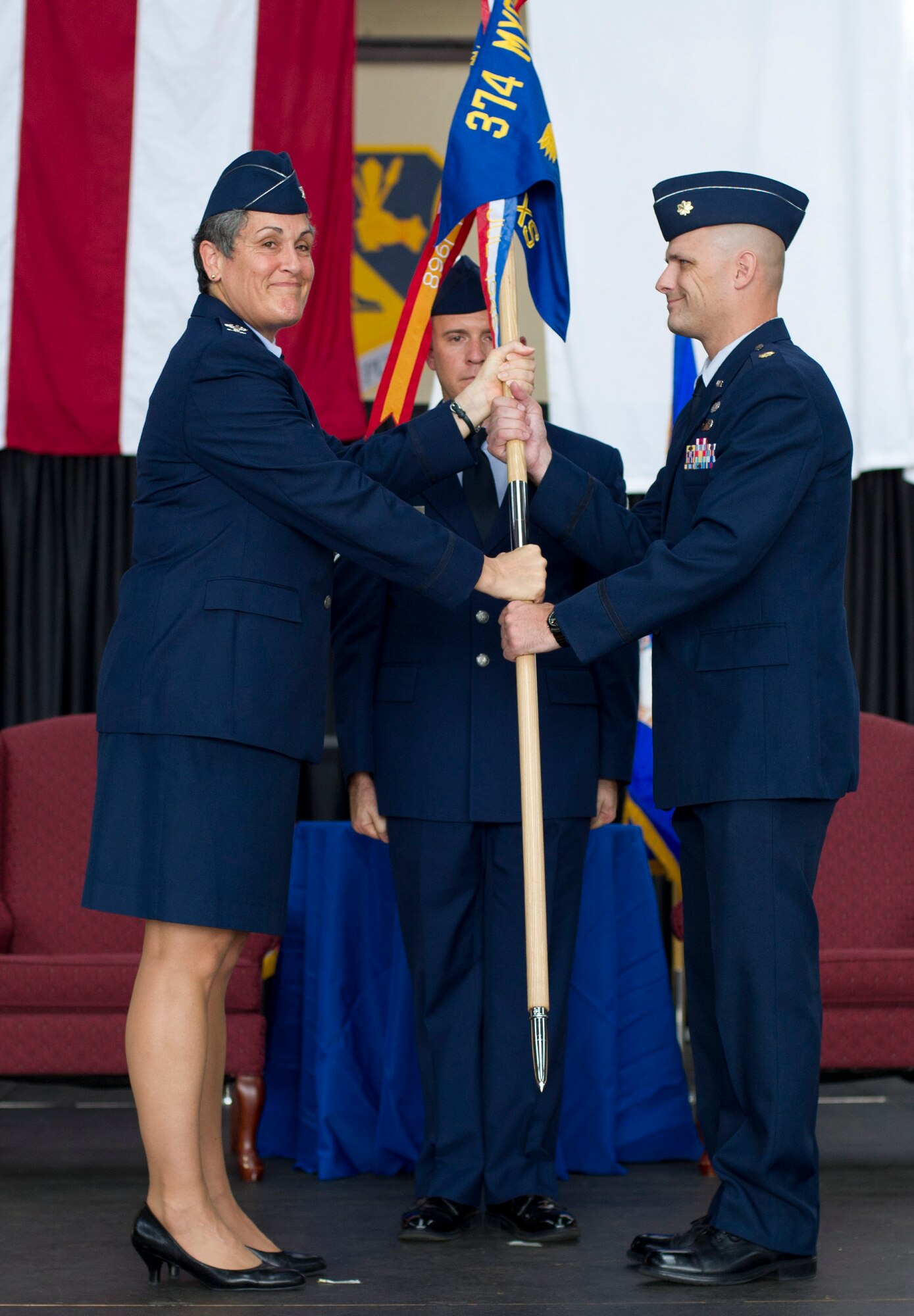 YOKOTA AIR BASE, Japan -- Col. Darlene Sanders, left, 374th Maintenance Group commander, passes the 374th Aircraft Maintenance Squadron guidon to Maj. Nicholas Pedersen, right, the new 374 AMXS commander, during an assumption of command ceremony at Yokota Air Base, Japan, July 13, 2012. Passing the unit guidon is symbolic of passing the responsibility of command, a tradition dating back to Roman times. (U.S. Air Force photo by Staff Sgt. Stacy Moless)