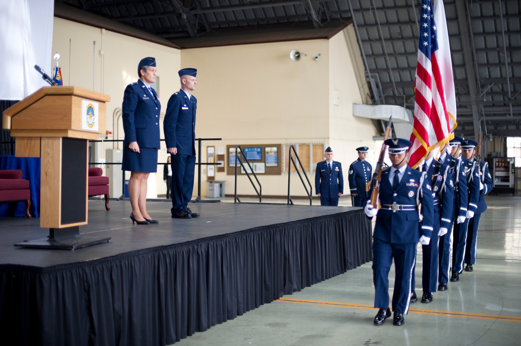 YOKOTA AIR BASE, Japan -- Col. Darlene Sanders, left, 374th Maintenance Group commander, and  Maj. Nicholas Pedersen, right, 374th Aircraft Maintenance Squadron commander, stand for the posting of the colors during the 374 AMXS assumption of command ceremony at Yokota Air Base, Japan, July 13, 2012. (U.S. Air Force photo by Staff Sgt. Stacy Moless)