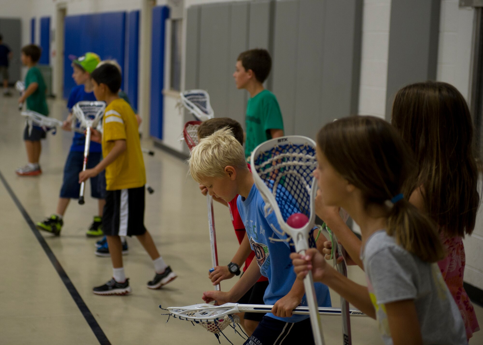 Children prepare to run a lacrosse drill during a Sideline Sports Camp at Holloman Air Force Base, N.M., July 13. The camp, which consisted of more than 20 children of Team Holloman, aims to expand each participant’s understanding of non-traditional sports, improve physical fitness, and develop an appreciation for the various sports offered. Each day of the camp, the Sideline Sports instructors introduced a new sport to the participants, including ultimate frisbee, handball, badminton, fencing and lacrosse. (U.S. Air Force photo by Senior Airman Siuta B. Ika/Released)