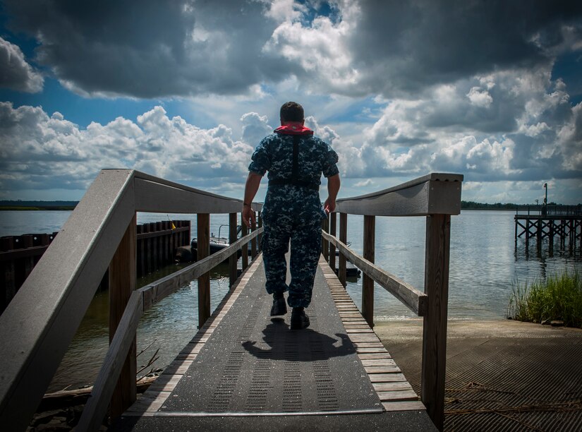 Chief Warrant Officer John Wilson, 628th Logistics Readiness Squadron Port Operations officer, walks down Pier Edwards, July 16, 2012 at Joint Base Charleston – Weapons Station. Wilson is responsible to the Joint Base Charleston commander for the overall safety of ship movements within the JB Charleston – Weapons Station port, which includes Wharf Alpha, Pier Bravo, Pier Charlie, Pier Edwards and the TC Dock. July 23, 2012 will mark Wilson’s 25th year in the Navy. (U.S. Air Force photo by Airman 1st Class Ashlee Galloway)