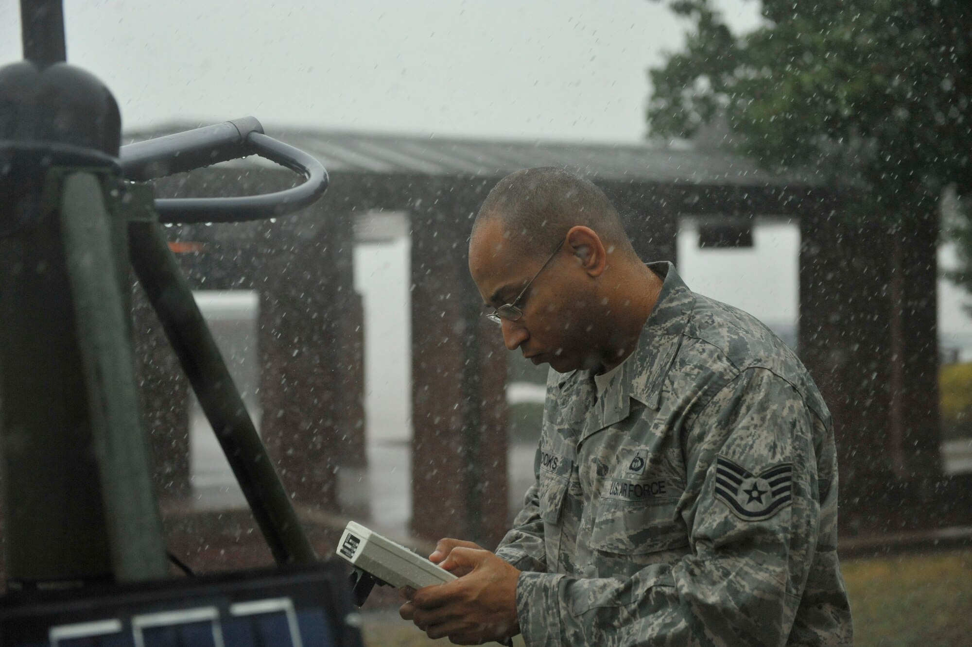 Staff Sgt. Alfred Brooks, a 19th Operations Support Squadron weather forecaster, checks a hand held sensor display during a rain storm July 10, 2012, at Little Rock Air Force Base, Ark. The meteorological equipment measures temperature, humidity, wind speed, wind direction, cloud height, precipitation and determines visibility.  (U.S. Air Force photo by Airman 1st Class Rusty Frank)