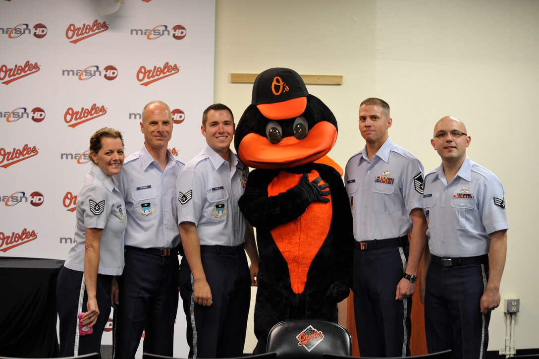 Members of the United States Air Force Academy Band's "Blue Steel" make friends with The Oriole Bird, mascot for the Baltimore Oriles.  Blue Steel performed the National Anthem during the opening ceremonies of the game.