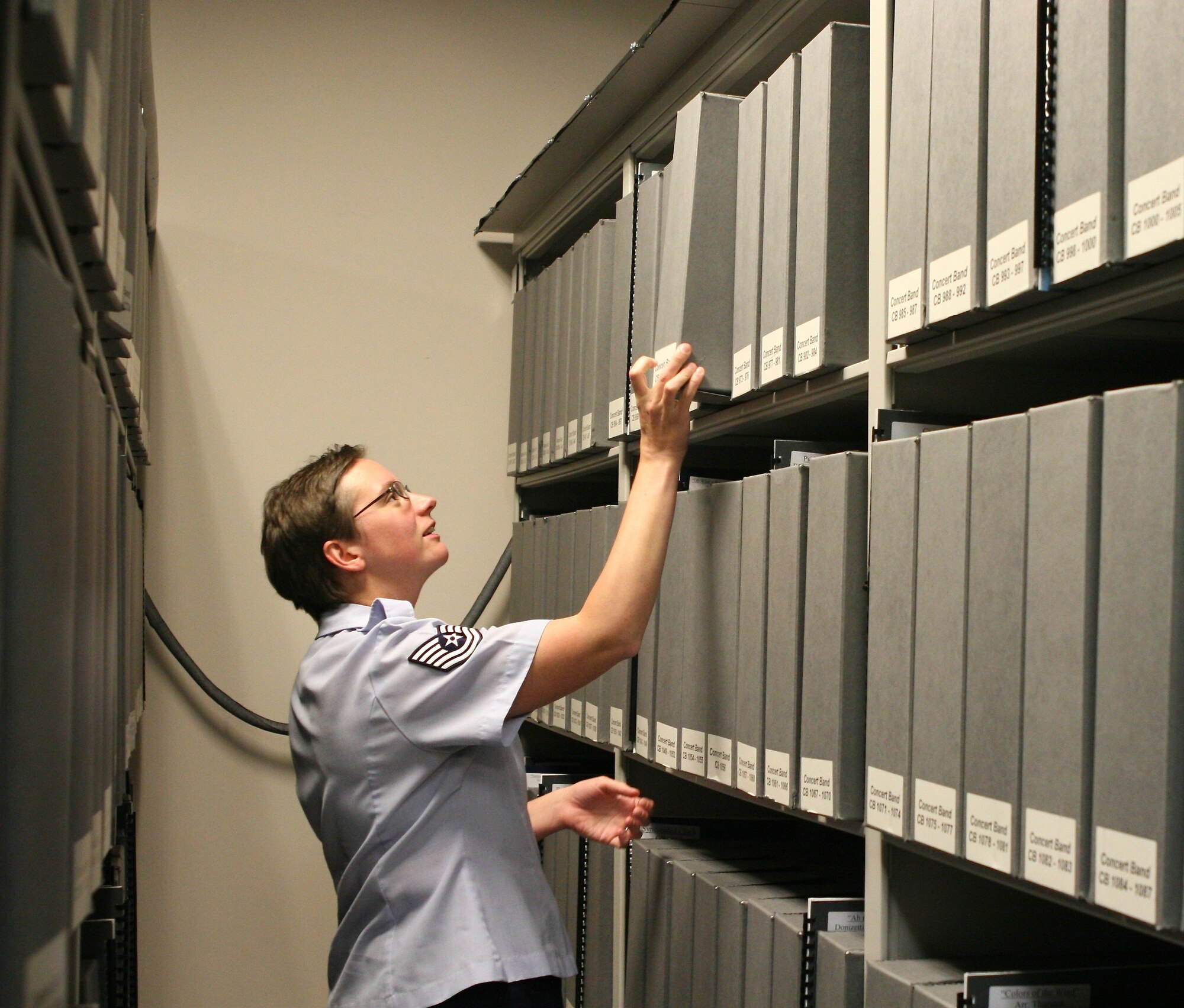 Tech. Sgt. Devon Landis combs the stacks for just the right piece of music.  (AF photo by CMSgt Jan Duga)

