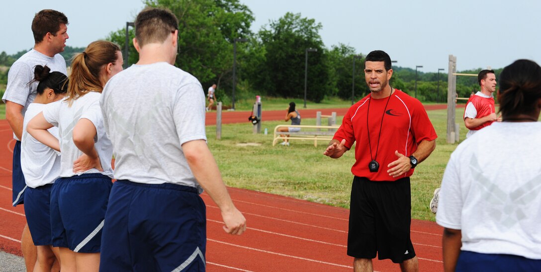Tony Arroyo, Health and Wellness Center exercise physiologist, explains proper form for running July 9 at Langley Air Force Base, Va. Participants ran laps so Arroyo could explain to each individual what needed to be done to improve their running form. (U.S. Air Force photo by Airman 1st Class Austin Harvill/Released)