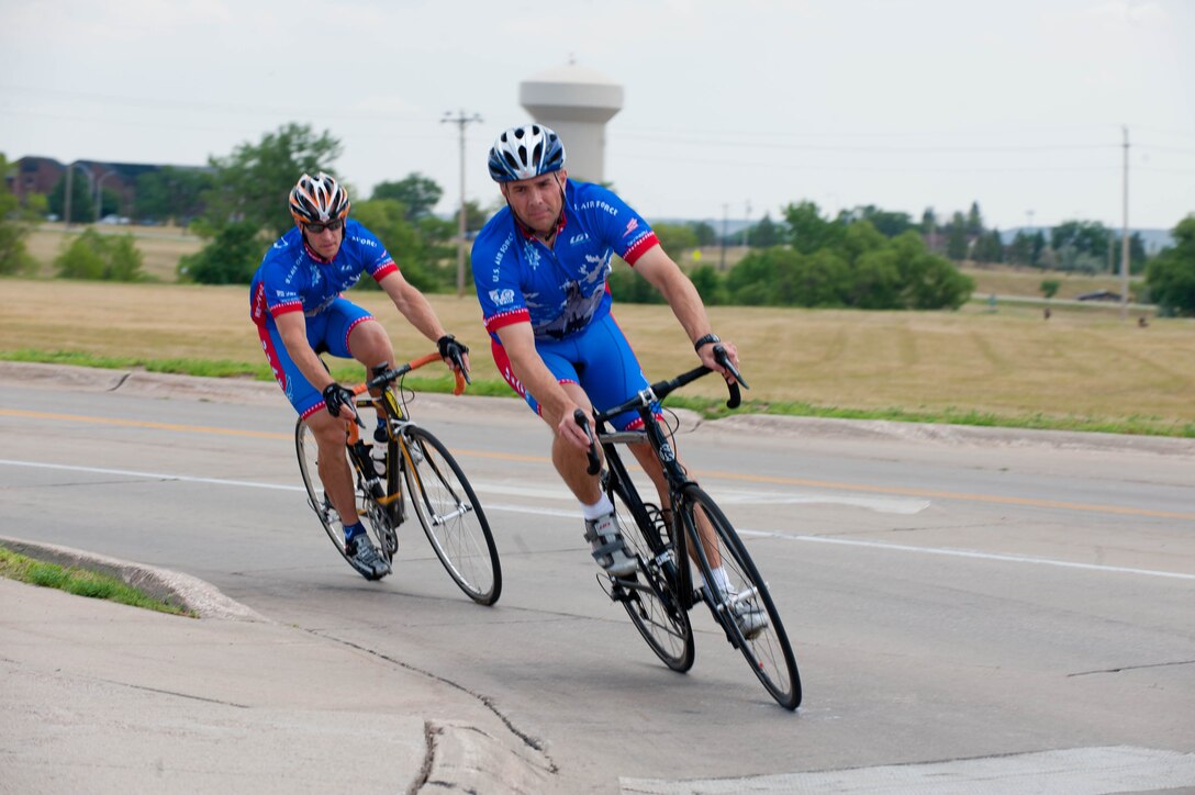 Lt. Cols. David Henshaw, 28th Operations Support Squadron director of operations, and Derek Leivestad, 28th Bomb Wing deputy chief of safety, ride their bikes across Ellsworth Air Force Base, S.D., July 17, 2012 to train for the Air Force cycling team’s annual trip to the Register’s Annual Great Bicycle Ride Across Iowa on July 22. The route changes every year, but the ride begins somewhere along Iowa’s western border on the Missouri River and ends along the eastern border on the Mississippi River.  Eight Iowa cities serve as host communities for overnight stays along the way. (U.S. Air Force photo by Airman 1st Class Zachary Hada/Released)