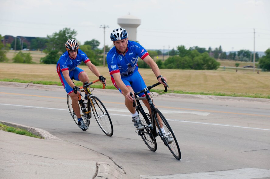 Lt. Cols. David Henshaw, 28th Operations Support Squadron director of operations, and Derek Leivestad, 28th Bomb Wing deputy chief of safety, ride their bikes across Ellsworth Air Force Base, S.D., July 17, 2012 to train for the Air Force cycling team’s annual trip to the Register’s Annual Great Bicycle Ride Across Iowa on July 22. The route changes every year, but the ride begins somewhere along Iowa’s western border on the Missouri River and ends along the eastern border on the Mississippi River.  Eight Iowa cities serve as host communities for overnight stays along the way. (U.S. Air Force photo by Airman 1st Class Zachary Hada/Released)