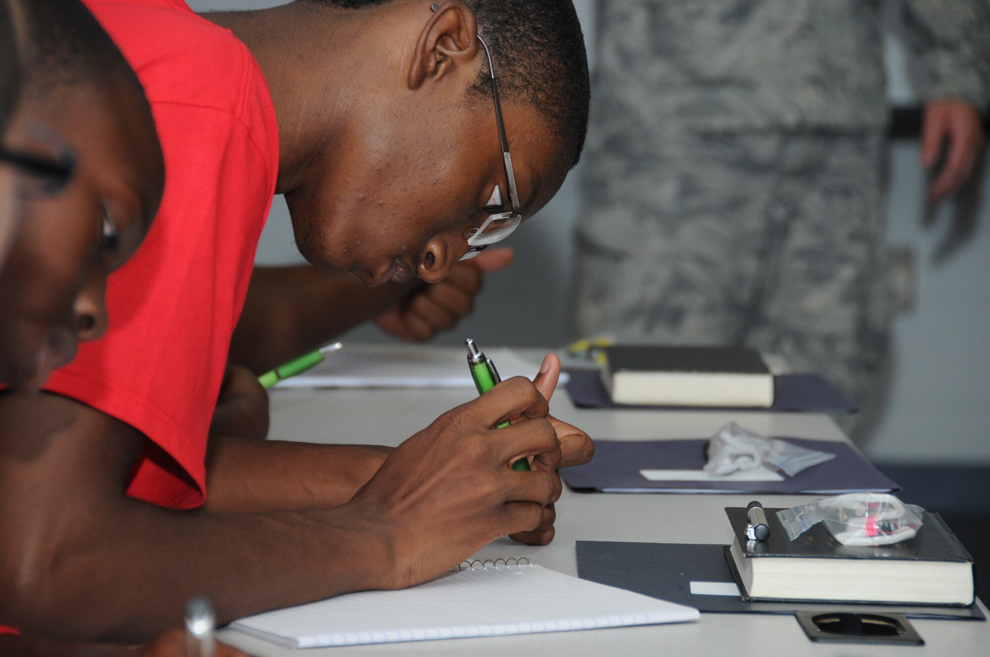 Seventeen-year-old Tydrik McNair, grandson of Tena McNair of Pearl, Miss., takes notes during Team Focus career night July 16, 2012, at the Sablich Center, Keesler Air Force base, Miss.  During career night, members of various squadrons on base briefed the young men on the details of their jobs in the Air Force.  The mission of Team Focus is to provide a year-round program of support, encouragement and values that foster the development of life skills in young men ages 10-18 without a father figure in their lives, bridging the fatherless gap and supporting the family structure.  (U.S. Air Force photo by Kemberly Groue)