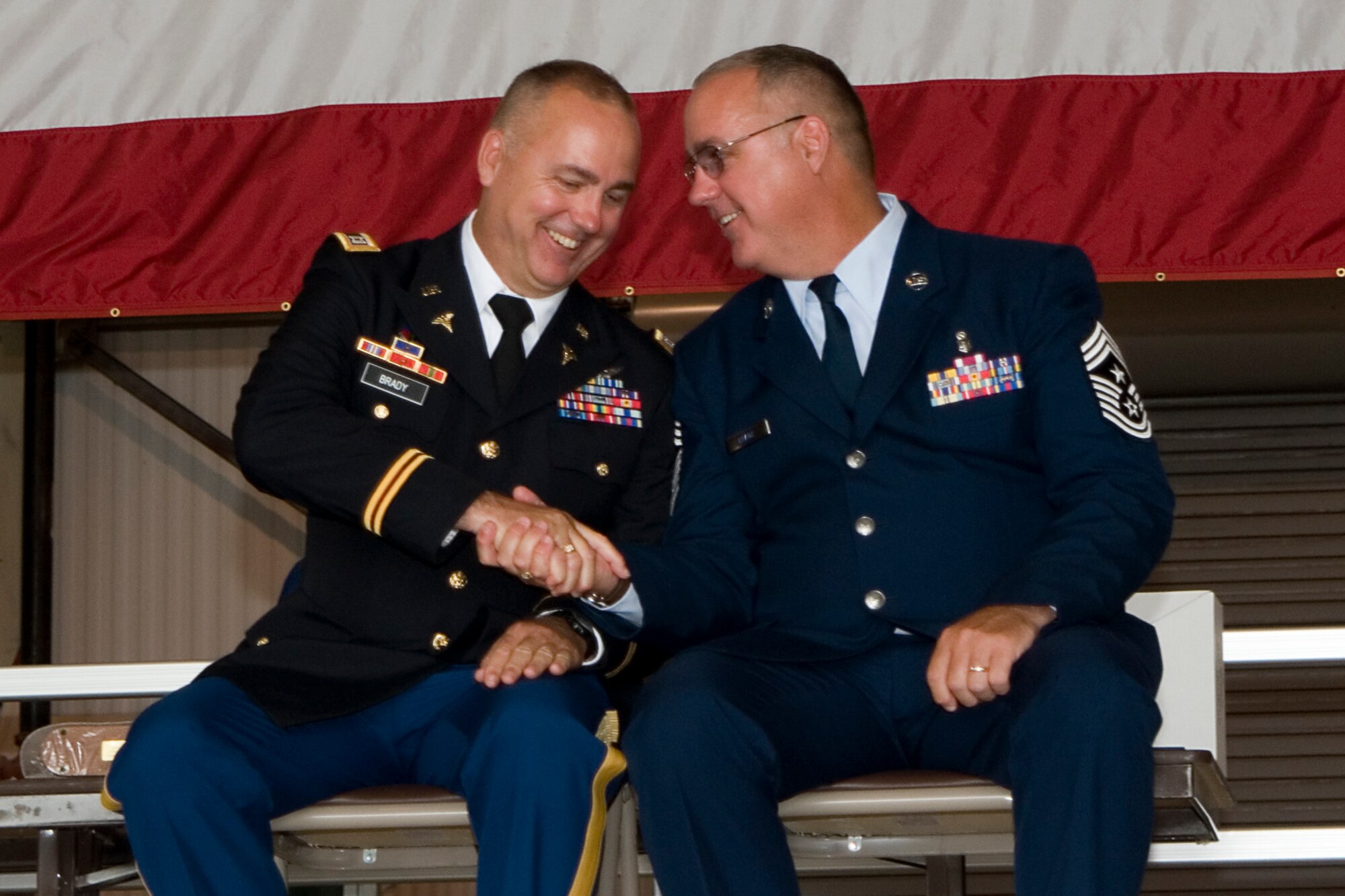 GRISSOM AIR RESERVE BASE, Ind. -- Chief Master Sgt. Larry Brady shakes hands with his brother Capt. Garry Brady during his retirement ceremony at Grissom July 8. Chief Brady was the 434th Air Refueling Wing command chief and Capt. Brady is a flight surgeon with the 4-3 Aviation Regiment at Hunter Army Air Field, Ga. (U.S. Air Force photo/Senior Airman Andrew McLaughlin)